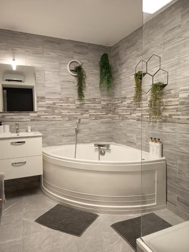 a bathroom with a bath tub and a sink at La maison de LYA (lyaroom) in Lallaing