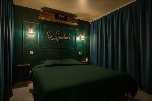 a bedroom with green walls and a bed in it at Le Sherlock - Cinéma privé & Enquête in Roanne