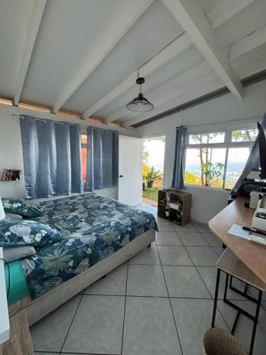 a bedroom with a bed and a desk at Manohei Lodge- Chambre indépendante Pamatai in Faaa