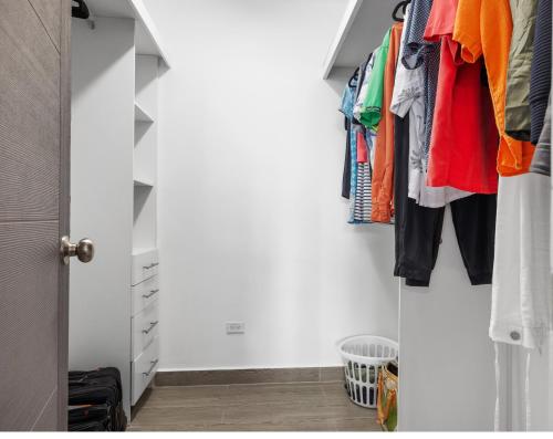 un dressing avec des vêtements colorés suspendus dans l'établissement Zimline Oceanfront, à Nueva Gorgona