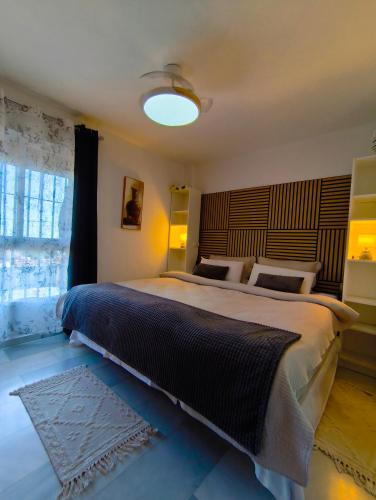 a bedroom with a large bed and a window at Paraíso del mar- Villa privada con piscina propia y vista al mar cerca de la playa in Fuengirola