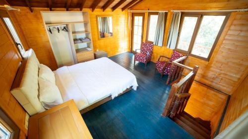 ein Schlafzimmer mit einem weißen Bett und einem Kühlschrank in der Unterkunft Welt Bungalows Belenbaşı in Hurmaköy