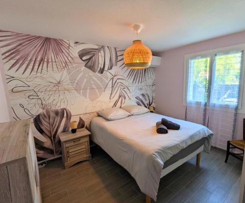 a bedroom with a bed and a wall with a mural at Maison 3 étoiles climatisée, jardin, parking, proche centre et thermes in Dax