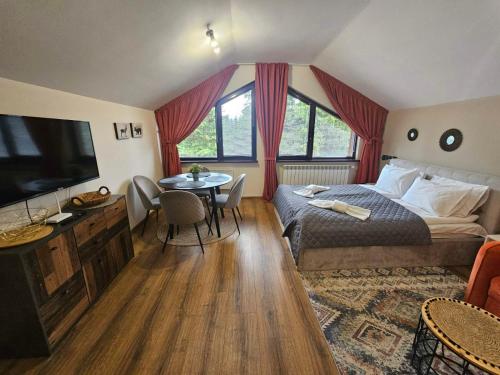 een slaapkamer met een bed, een tafel en een televisie bij Rustic Mountain Apartment - A55 in Borovets