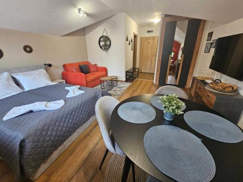 een slaapkamer met een bed, een tafel en stoelen bij Rustic Mountain Apartment - A55 in Borovets