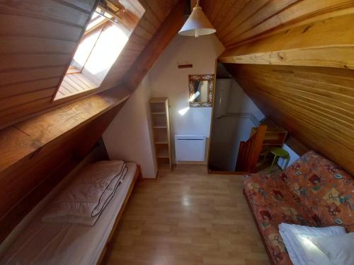 een zolderkamer met een bed en een raam bij logement moderne in Campan