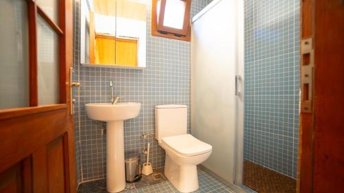 ein blau gefliestes Badezimmer mit Toilette und Waschbecken in der Unterkunft Welt Bungalows Belenbaşı in Hurmaköy