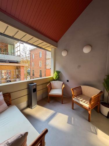 a balcony with a bed and a bench and a window at Ruby Hostel, Kutaisi - Private & Shared Rooms in Kutaisi