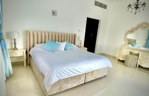 a bedroom with a large bed with blue pillows at Al Dana Palma Villa - Luxury 4-bedroom villa with Heated Pool & Mountain Sea View in Fujairah