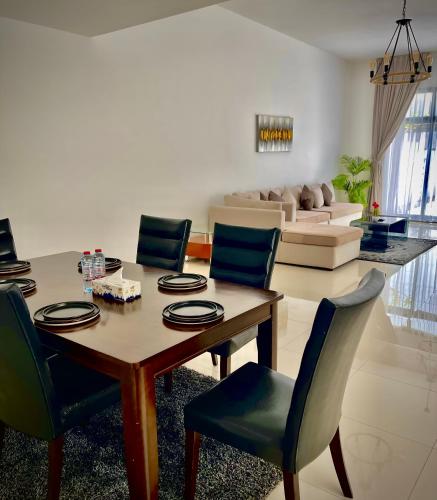 a living room with a dining room table and chairs at Al Dana Palma Villa - Luxury 4-bedroom villa with Heated Pool & Mountain Sea View in Fujairah