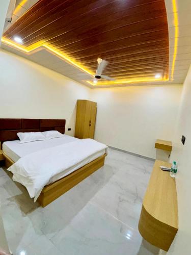 a bedroom with a bed and a wooden ceiling at The Brij Retreat , 50 mtr from Shri Krishna Janambhumi in Mathura
