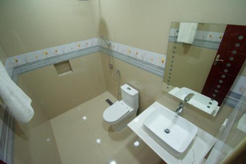 a bathroom with a white toilet and a sink at Villaasa in Shaviyani Atoll