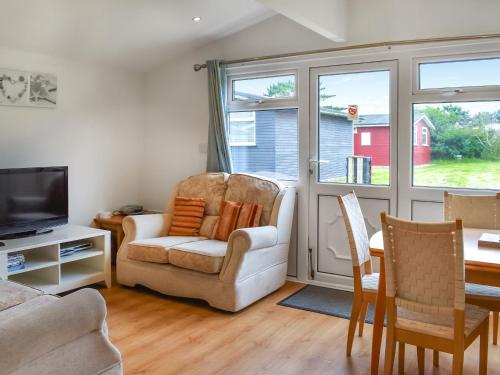 ein Wohnzimmer mit Sofa, Sesseln und Fernseher in der Unterkunft Boobys Bay - Uk47554 in Saint Merryn