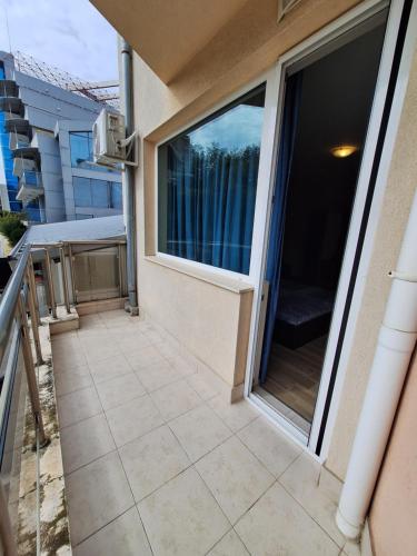 a balcony with a large window on a building at Бобс апартаменти 1 in Kiten