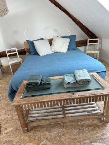 een slaapkamer met een bed met blauwe lakens en kussens bij la Crémesine in Baratier
