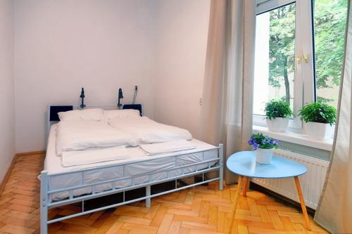 a bed in a room with a table and a window at Warsaw Hostel Centrum Private Rooms & Dorms in Warsaw