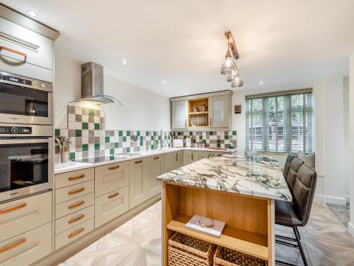 Wainfleet All SaintsにあるMr George- Uk34816のキッチン(白いキャビネット、大理石のカウンタートップ付)