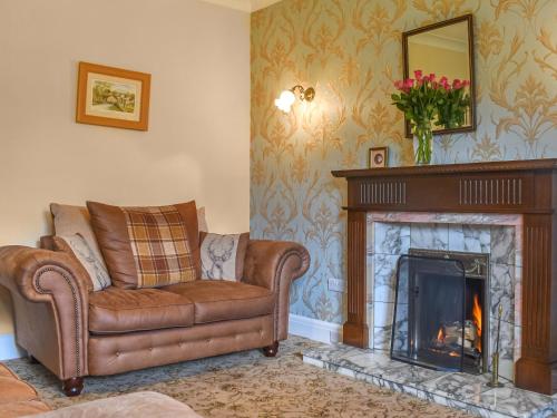 ein Wohnzimmer mit Couch und Kamin in der Unterkunft Melrose in Clitheroe