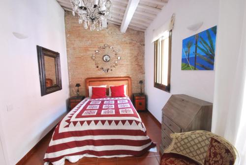 a bedroom with a bed with red pillows and a chandelier at Fraternitat SDB in Barcelona