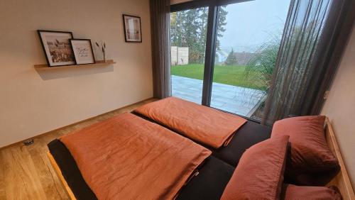 un soggiorno con un divano e una grande finestra di Wallys Auszeit a Grub am Forst