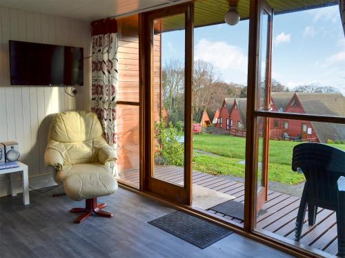 a living room with a chair and a sliding glass door at Bay View in Kingsdown