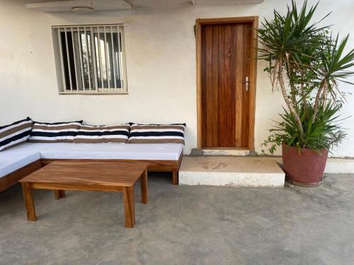 a room with a couch and a table and a door at Lou Fatm' Popenguine in Poponguine