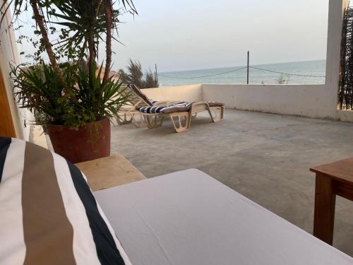 a patio with a chair and a view of the ocean at Lou Fatm' Popenguine in Poponguine