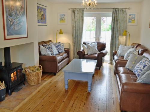 a living room with couches and a coffee table at Woodbrook Cottage in Bridport