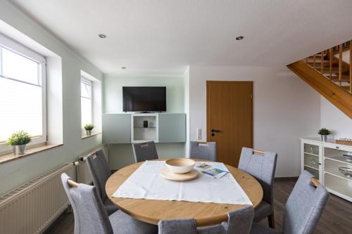 a dining room with a wooden table and chairs at Inselglück App 4 in Norderney