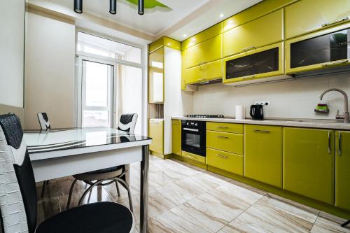 una cucina con mobili gialli, un tavolo e delle sedie di Testimiteanu One a Chişinău