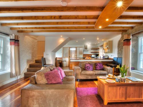 a living room with two couches and a table at Rhosson Chapel Cottage in St. Davids