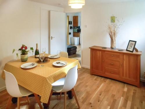 una sala da pranzo con tavolo e tovaglia gialla di Fawns Cottage a Culmstock