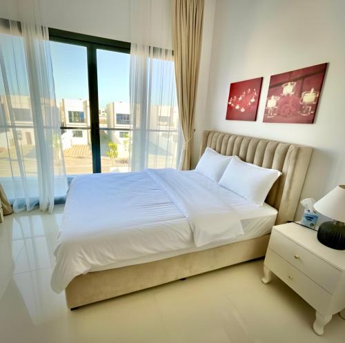 a bedroom with a bed and a large window at Al Dana Palma Villa - Luxury 4-bedroom villa with Heated Pool & Mountain Sea View in Fujairah