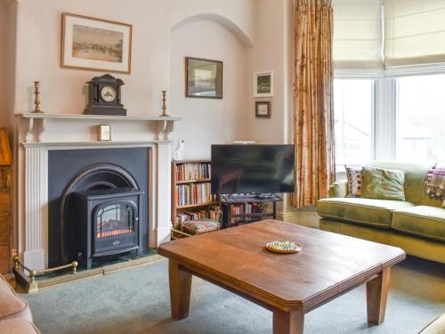 a living room with a fireplace and a coffee table at Hillside House in Kirkby Lonsdale