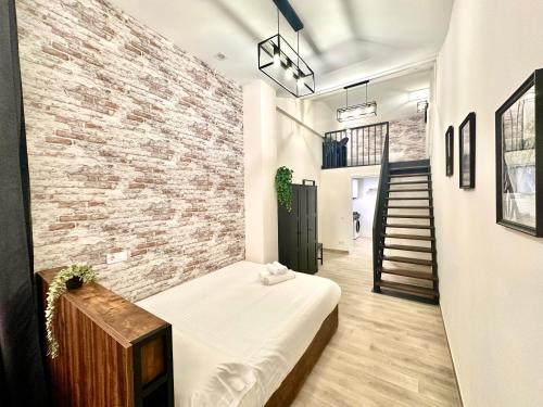 een kamer met een bed en een bakstenen muur bij Ciudades de España in Valencia