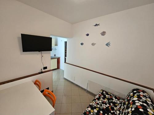 een kamer met een bank en een tv aan de muur bij Tana sul mare in Rimini