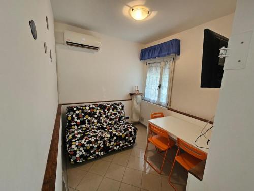 a room with a bed and a table and chairs at Tana sul mare in Rimini