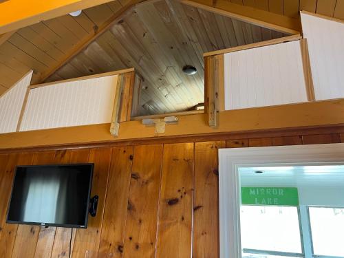 a room with a tv and a ceiling with wooden walls at Cottage 12 - King Bed Child Loft w Twin Private Bath Kitchenette Pets Allowed Fee applies in Wolfeboro