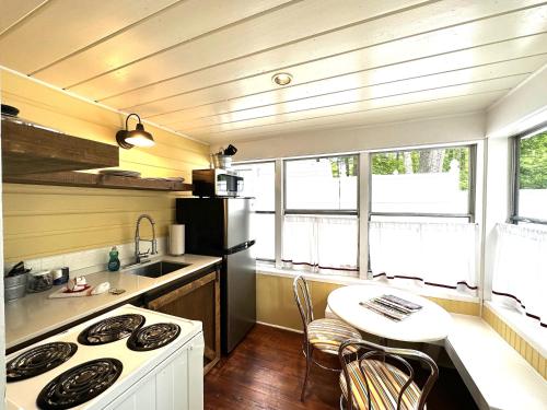 a small kitchen with a table and a stove at Cottage 12 - King Bed Child Loft w Twin Private Bath Kitchenette Pets Allowed Fee applies in Wolfeboro