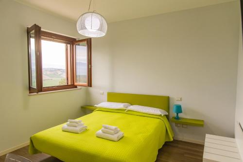 Morro dʼOroにあるCountry House Torreneraのベッドルーム1室(黄色いベッド1台、タオル付)
