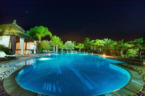 a large blue swimming pool at night at Ksar Salha in Marrakech