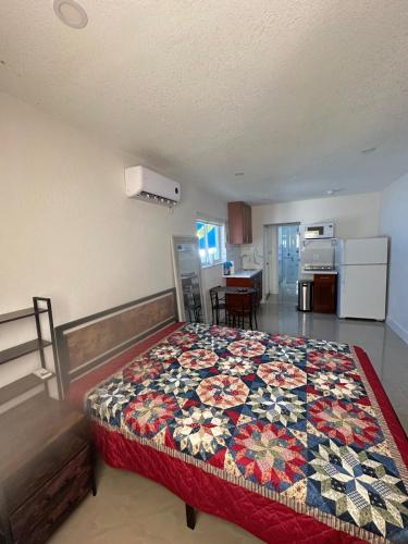 a bedroom with a bed with a colorful quilt on it at Miramar's Studio in Miramar