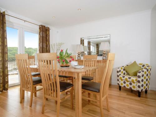Un comedor con mesa y sillas en Woodpecker-Qc1186, en Milford Haven