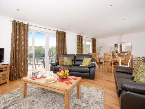 una sala de estar con un sofá y una mesa en Woodpecker-Qc1186, en Milford Haven