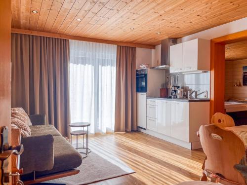 a living room with a couch and a kitchen at Aparthaus Bianca in Gaschurn