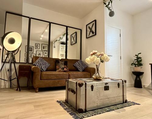 a living room with a couch and a vase of flowers at The Cambria in Ipswich
