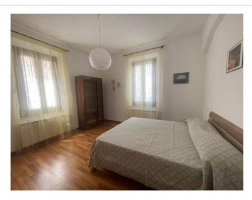 a bedroom with a bed and two windows at In Centro a Senigallia in Senigallia