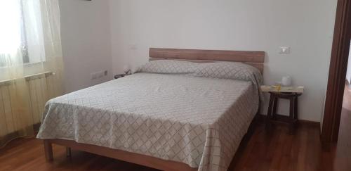 a bedroom with a bed with a white comforter at In Centro a Senigallia in Senigallia