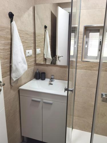 a bathroom with a white sink and a mirror at Villa Mayki in Cacicedo