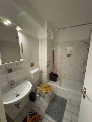 une salle de bain avec un lavabo, des toilettes et une baignoire dans l'établissement CityStay Dortmund, à Dortmund